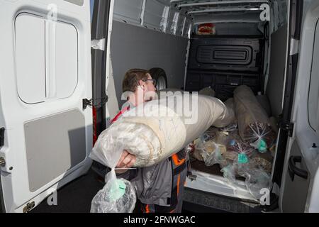 Worker standing near truck full of carpets. Cleaning service concept Stock Photo