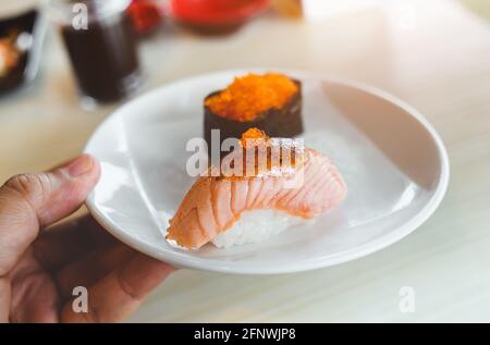 Salmon sushi grill top with sweet miso by indoor low and warm lighting. Stock Photo