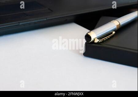 Pen and notebook on a sheet of paper. The space for the inscription. Stock Photo