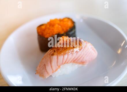 Salmon sushi grill top with sweet miso by indoor low and warm lighting. Stock Photo