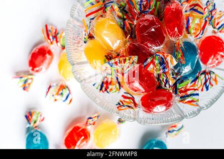 Bowl full with mix hard wrapped candies isolated on white background. Stock Photo