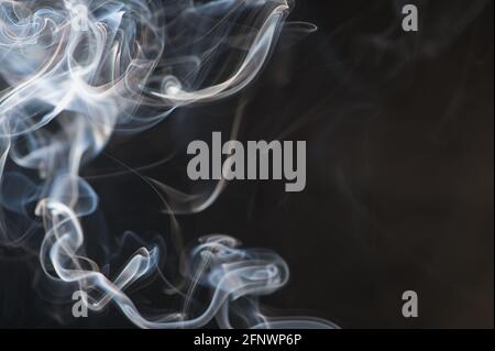 blurry smoke of an incense stick as background photo with copy space Stock Photo