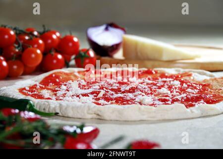 Neapolitan margherita pizza with a high dough base of mozzarella, cheese, buffalo mozzarella, tomato sauce, basil. Raw pizza dough ready to be baked i Stock Photo
