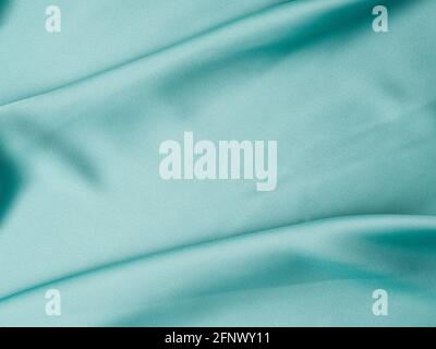 Green satin texture background with waves and crease Stock Photo