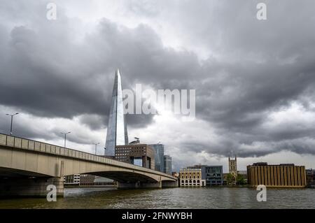 London, UK: View from the City of London looking south across the River Thames with London Bridge and the Shard building. Storm clouds gathering. Stock Photo