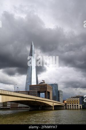 London, UK: View from the City of London looking south across the River Thames with London Bridge and the Shard building. Storm clouds gathering. Stock Photo