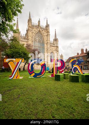 Free standing letters spelling the word York on College Green, College Street, with the Great East Window of York Minster behind. York. UK Stock Photo