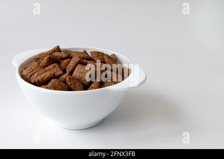 chocolate pads in bowl isolated on white background, chocolate corn pads, healthy breakfast Stock Photo