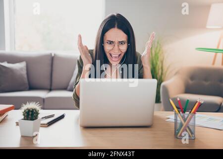 Photo of young angry furious stressed woman in glasses has video call speak tell explain problem trouble at home house Stock Photo