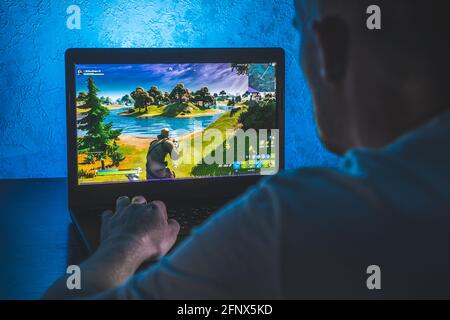 Person playing fortnite video game on computer Stock Photo
