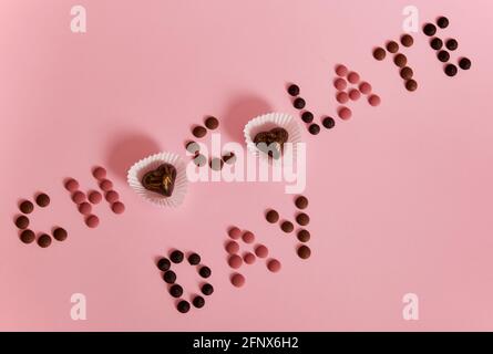 Chocolate multi colored pills laid out in a line on a red background