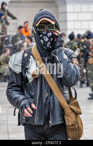 Stalker soldier with gas mask and leather jacket walking in the danger radioactive urban zone and talking mobile phone. Post apocalypse. Nuclear war. Stock Photo