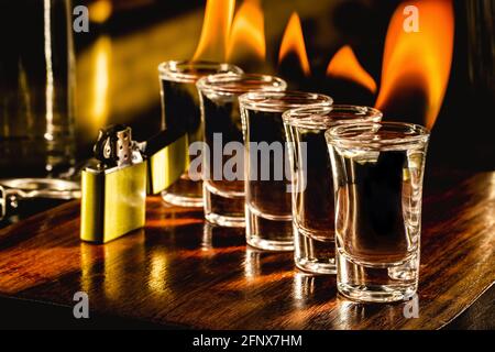 glasses with tequila shots on fire, flaming drink, bar setting Stock Photo