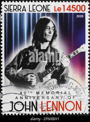 John Lennon playing the guitar on postage stamp Stock Photo