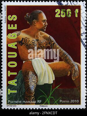 Portrait of tattoed man on polynesian postage stamp Stock Photo