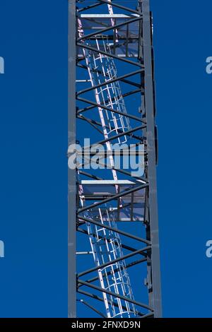 Ladder in the mast of a white tower crane against a beautiful blue sky. Building a hi-rise condo in Ottawa, Ontario, Canada. Stock Photo