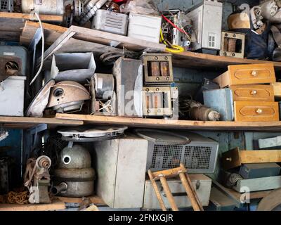 Full shelves of vintage equipment and things in abandoned garage, Clutter, unnecessary things Stock Photo