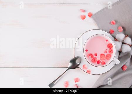 Pink matcha with rose petals. Relaxing drink for sleepy time. Trendy vegan tea on a white background. Place for text Stock Photo
