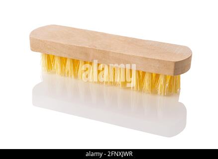 New wooden cleaning brush with yellow coarse stiff bristles isolated on white background. Simple tool for housework close-up. Сleaning supplies design Stock Photo