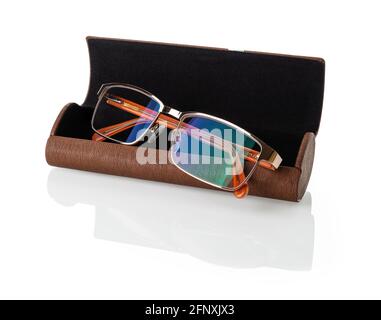 Eyeglasses with golden rim in an open brown case isolated on a white background. Glasses for vision correction in a stylish artificial leather case. Stock Photo