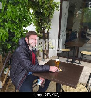 L'isle Adam, France. 19th May, 2021. Mathieu, a kindergarten teacher, drinks a beer at the terrace of L'Etang brasserie in L'Isle-Adam, north Paris, France, on May 19, 2021. France on Wednesday took an important step forward toward returning to normality as people in the country can once again meet up in cafes or enjoy a meal in restaurants, which are now allowed to open their terraces. Credit: Sonia Ounissi/Xinhua/Alamy Live News Stock Photo