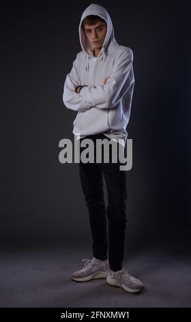 Portrait of a young attractive man dressed in white hoodie and skinny black  jeans Stock Photo - Alamy