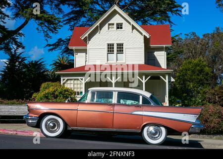Classic 1957 Chevrolet Bel Air four door sedan parked on on the street in front of eclectic Queen Anne architecture style historic building - San Fran Stock Photo