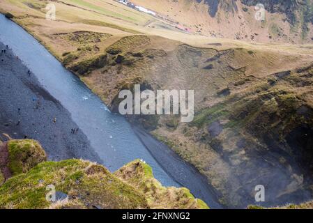 Looking over the edge of a mossy canyon in Iceland where down below you can see a dark river bed. Stock Photo