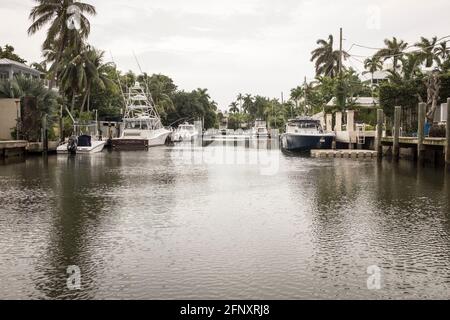 Luxury boats at their private moorings outside luxury waterfront homes in Coconut Grove, Miami, Florida Stock Photo