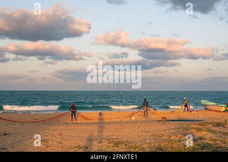 Fishermen on the beach tending to their fishing nets just before sunset, Mullaitivu, Northern Province, Sri Lanka Stock Photo
