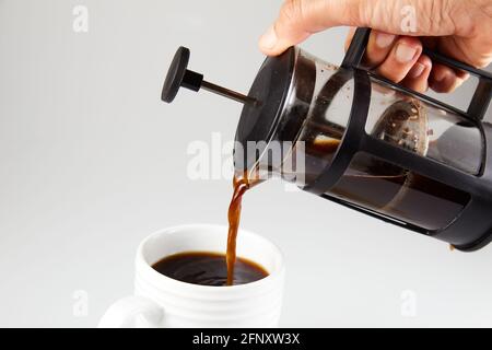 Pouring coffee in a cup from a french press close up Stock Photo