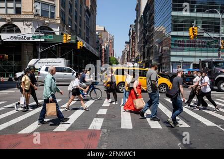 New York, USA. 19th May, 2021. Pedestrians cross Broadway in the SoHo neighborhood in New York, United States, May 19, 2021. New York State entered a new period of reopening on Wednesday with multiple capacity restrictions lifted and new guidance on masks and social distancing taking effect. Credit: Michael Nagle/Xinhua/Alamy Live News Stock Photo