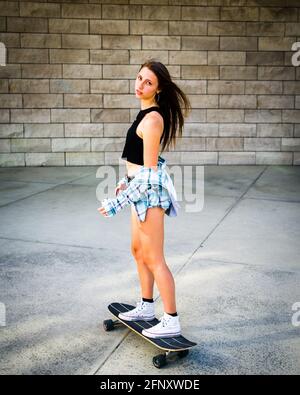 Young Woman Riding a Skateboard in a Downtown Urban Area Stock Photo