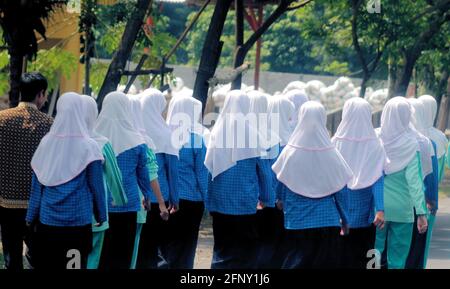 A group of Muslim older girls walking to school on a sunny day in Lombok, Indonesia. Stock Photo
