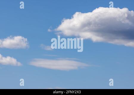 white puffy clouds on a bright blue sky Stock Photo