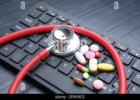 Close up of pills and stethoscope on keyboard  Stock Photo
