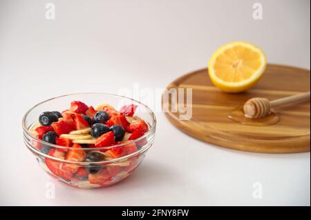 Healthy berry fruits with honey and lemon on white background Stock Photo