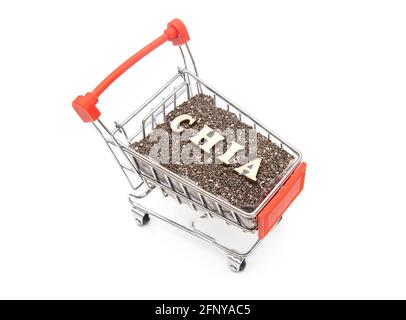 Top-side view of a miniature shopping trolley full of chia seeds and CHIA lettering made of wooden letters isolated on white Stock Photo