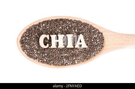 A wooden spoon full of chia seeds and CHIA lettering made of wooden letters on top isolated on white Stock Photo