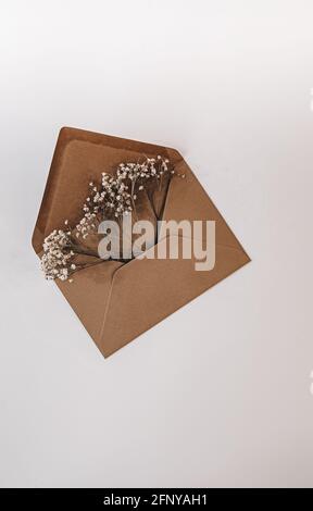 Brown envelop filled with flowers for wedding, birthday, or graduation. Mood and lifestyle pictures for Instagram and Pinterest Stock Photo