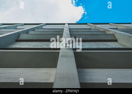 industrial camera on the wall of a concrete building with the sky in the background Stock Photo