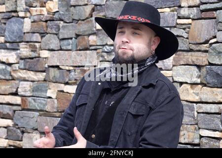 Man in black lether and denim outfit with cowboy hat Stock Photo