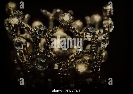 Gold crown with shiny stones on a black background. Stock Photo