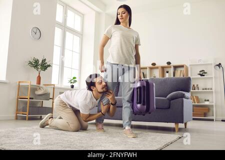 Husband begging angry wife who is leaving home to stay and give him second chance Stock Photo