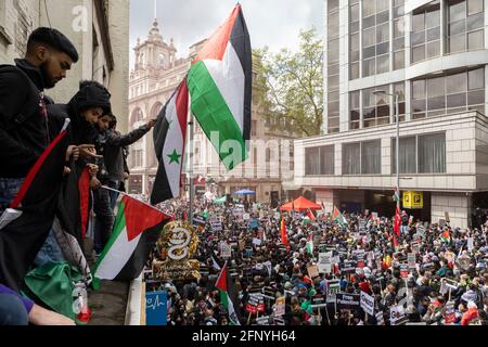 Protesters wave flags over crowd from side of building, 'Free Palestine' solidarity protest, London, 15 May 2021 Stock Photo