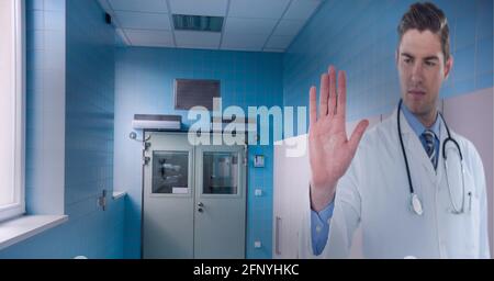 Caucasian male doctor touching invisible screen against hospital in background Stock Photo