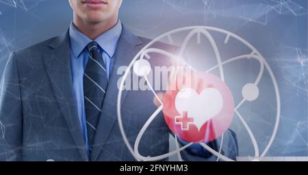 Heart icon and and network of connections over mid section of businessman touching invisible screen Stock Photo