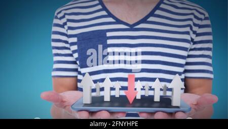 Multiple arrows over mid section of man holding digital tablet against blue background Stock Photo