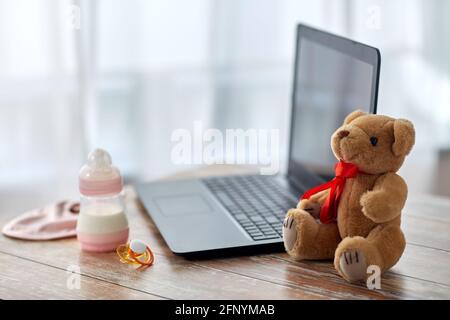 baby milk formula, laptop, soother and teddy bear Stock Photo