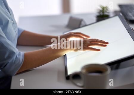 hands on led light tablet at night office Stock Photo